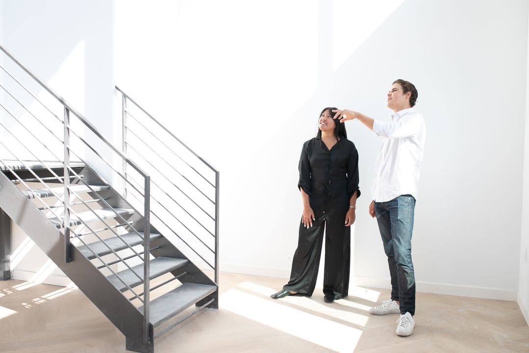 Two Lyra agents walking a client through a bright, modern unit